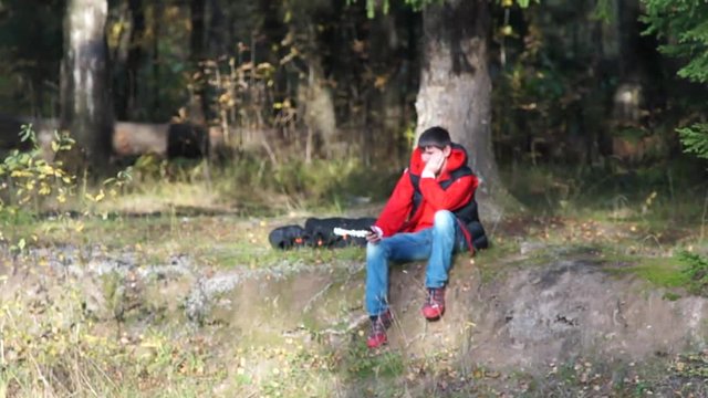 Юноша остановился на отдых у реки или пруда в лесу осенним вечером 1