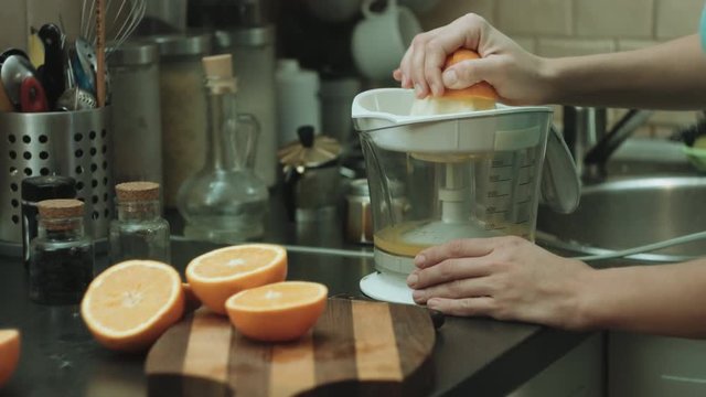 Close-up shot of the woman makes orange fresh on the kitchen