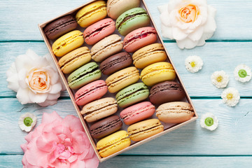 Colorful macaroons in a gift box and roses