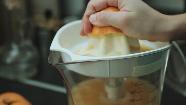 Close-up shot of the woman makes orange fresh on the kitchen
