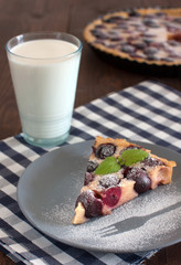 French clafoutis with cherries and milk in glass