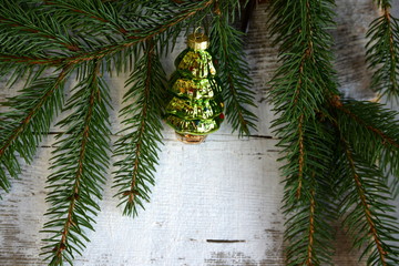 Tannenbaum, bemaltes Holzbrett, mit Fichtenzweigen und Weihnachtsbaumanhänger in Form eines Tannenbaums