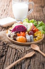 Mix fruits salad on wood plate with milk
