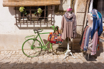 Vintage bicycle leaning against an old door in a medieval street in Obidos