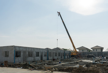 Fototapeta na wymiar Construction site crane is used to placing precast concrete pane
