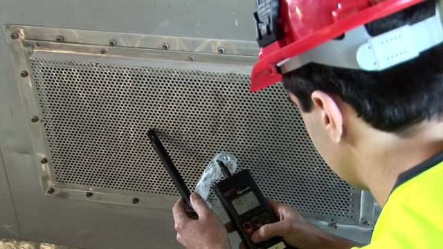 Over shoulder on professional testing air quality in ventilator shaft