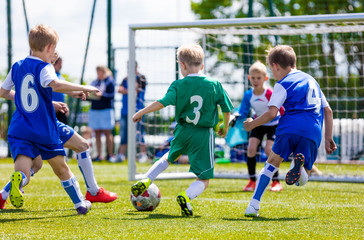 Football soccer match for children. Boys playing football game on a school tournament. Dynamic, action picture of kids competition during playing football. Sport background image. - obrazy, fototapety, plakaty
