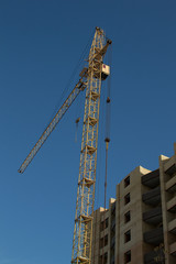 стройка высотного здания при помощи подъемного крана