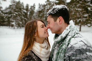 Fototapeta premium Young beautiful couple having fun and enjoying the snowy weather.