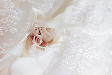 Cute background with laces and silk rose. Details of newborn baby girl's dress.