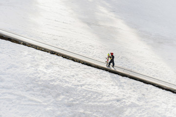 A little snowboarder on a magic carpet ski lift.