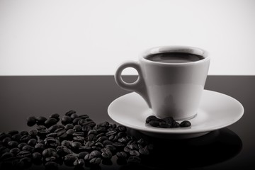 Coffee cup with coffee beans surrounding 