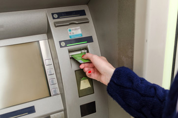 Young red woman using the cash machine