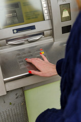 Young red woman using the cash machine