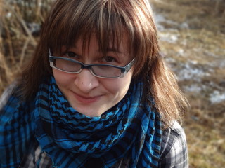Happy girl in glasses and in plaid scarf portrait