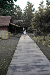 Fototapeta na wymiar Woman walking on wooden walk way