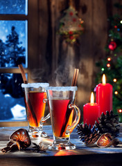 close up view  of glasses  with mulled wine with gift boxes on color back
