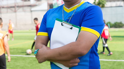 Coach is coaching Children Training In Soccer Team
