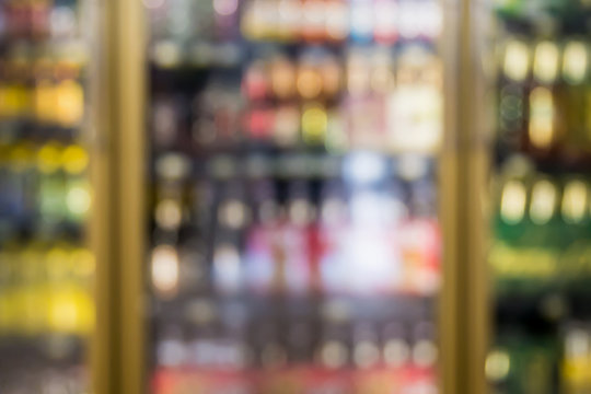 blur bottles of beverage on shelves in the freezer at supermarke