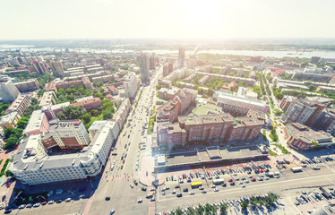 Aerial city view with crossroads and roads, houses, buildings, parks and parking lots, bridges. Urban landscape. Copter shot. Panoramic image.