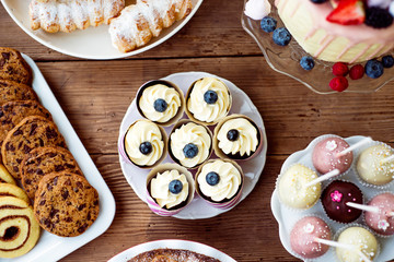 Table with cupcakes, cookies, cakepops and horn pastries.