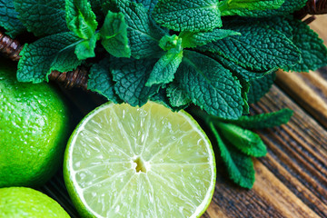 Fresh citrus lime and mint closeup on wooden background
