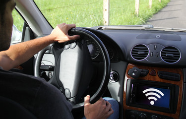 young man driving a connected electric car © MclittleStock