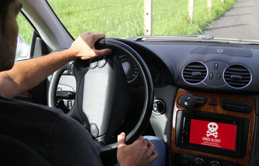 young man driving an electric car showing on-board screen comput