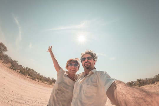 Adult couple taking selfie in the Namib desert, Namib Naukluft National Park, main travel destination in Namibia, Africa. Fisheye view in backlight, adventures in Africa. Toned image.