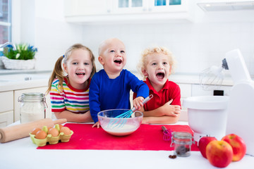 Kids baking a pie in white kitchen