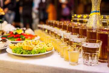 catering banquet table, Canapes on restaurant table, catering, buffet, canapés, stemware, snacks, glasses with juice, champagne glasses