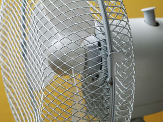closeup of table fan, focus on grid, shallow depth of field
