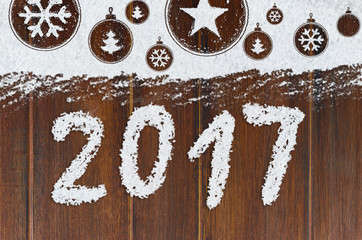 christmas card or new year background made of xmas symbols handwritten on snow and wooden table