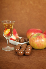 Glas Calvados mit Schokoladen Kugeln und roten Äpfeln