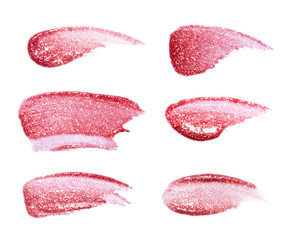 Different lip glosses isolated on white. Smudged lip gloss sample