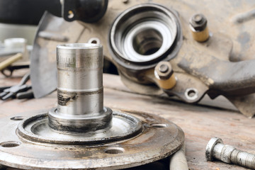 Old, oiled wheel hub lies on a wooden table