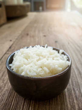 Cooked jasmine rice in a bowl on wooden table