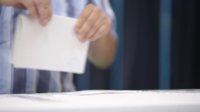 Unrecognizable people cast their vote during elections in a voting station