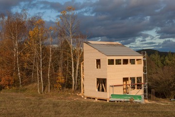 Construction of ecological house. External work on the building envelope. The wooden structure of the house near the forest.
