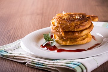 Few apples in dough with jam on white plate and cloth