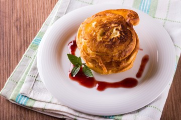 Few apples in dough with jam on white plate and towel