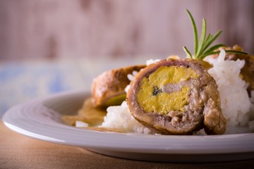 Meat rolls filled by eggs with rice on plate and wooden board