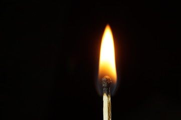 A burning matchstick in the dark environment