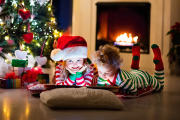 Kids in pajamas under Christmas tree