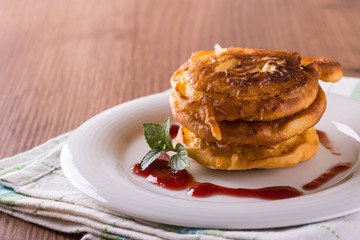 Apples in dough with jam on white plate and green mint