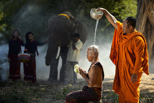 Monk giving water blessing to another monk