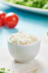 Cottage cheese in white bowls - tomatoes in background