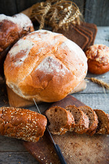 Fresh bread and wheat on the old wooden table