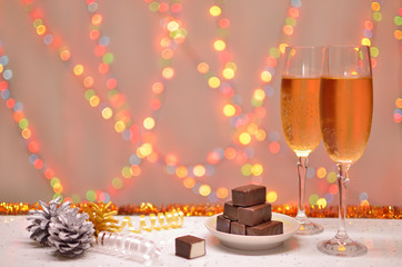 Naklejka na ściany i meble Glass champagne and chocolate on the christmas background spots light