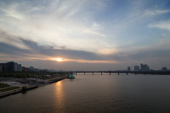 View of a park in the river shore and bridge at the Han River in Seoul, South Korea, at sunset. Copy space.